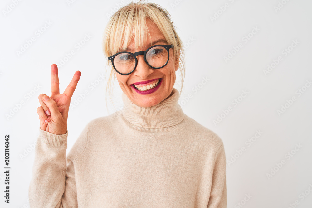 Middle age woman wearing turtleneck sweater and glasses over isolated white background smiling with happy face winking at the camera doing victory sign. Number two. Middle age woman wearing turtleneck sweater and glasses over isolated white background smiling with happy face winking at the camera doing victory sign. Number two.