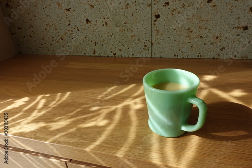 テーブルに置かれたコーヒーカップ カーテン越しの光の中で cup of coffee on table
