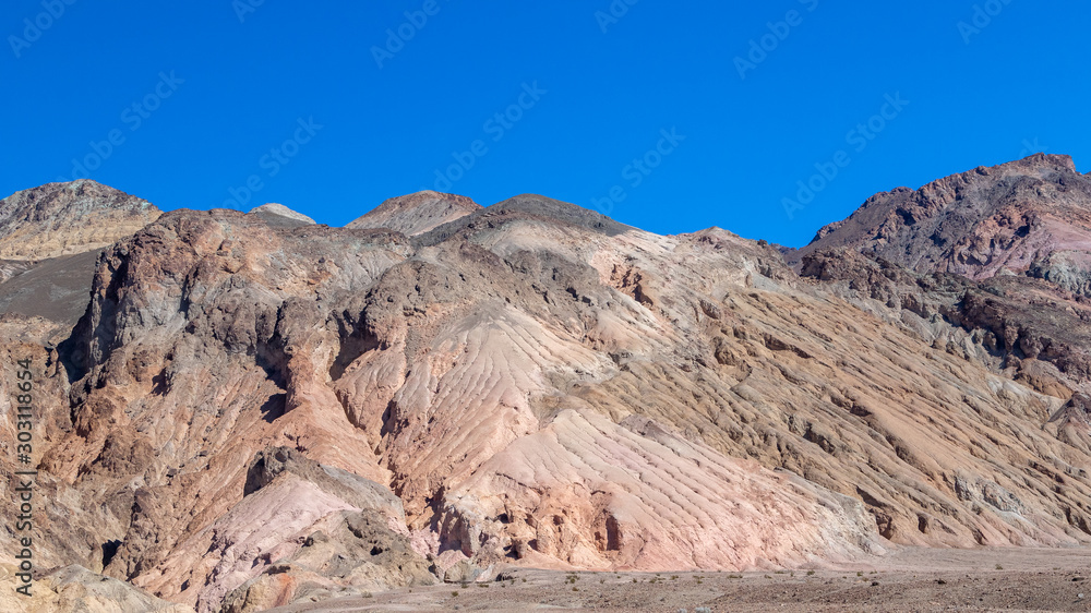 Interesting rock formations on Artist's drive in Death Valley National Park in California. Clear blue sky background