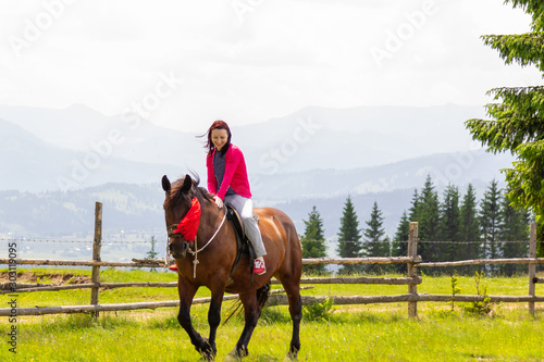 Young woman riding a horse in a mountain area