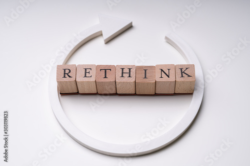 Fotografie Wooden Blocks With Rethink Word And Arrow Over White Background