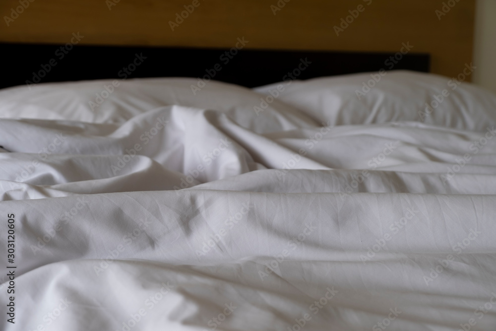 Obraz premium Crumpled messy white blanket untidy, Unmade bed sheet after waking up in the morning texture