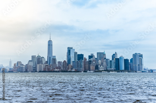 Cityscape of the financial district of Manhattan from Liberty Island, in a foggy day. © dhvstockphoto