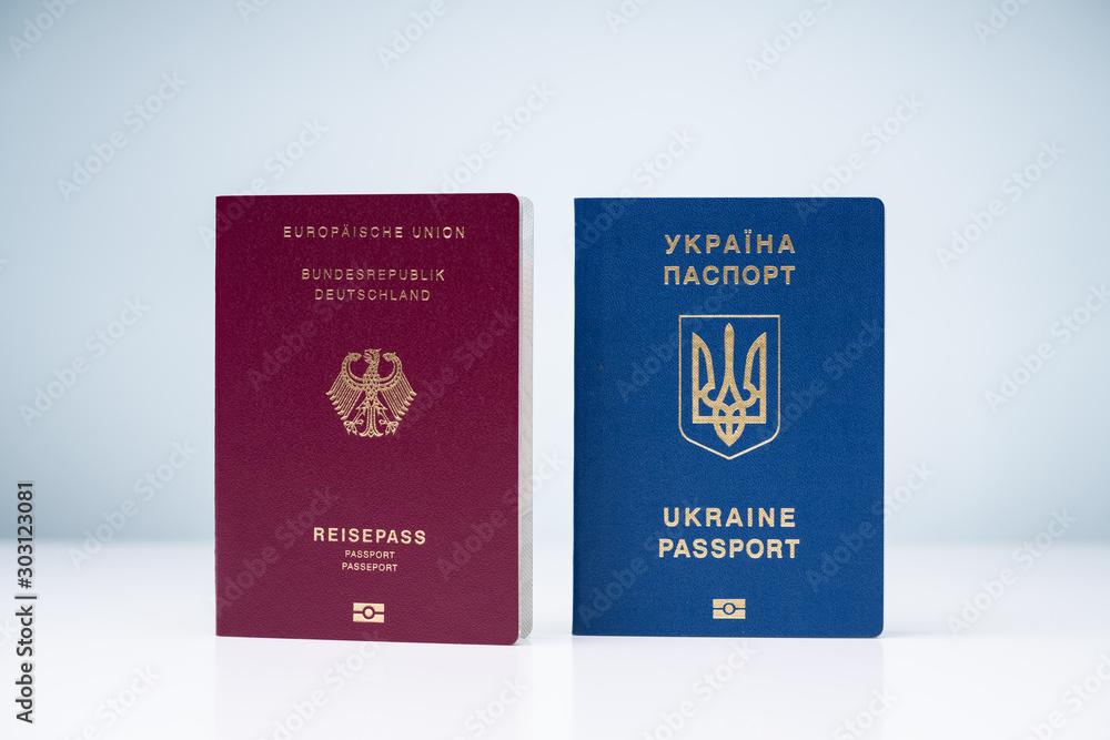German And Ukrainian Passports Against White Surface