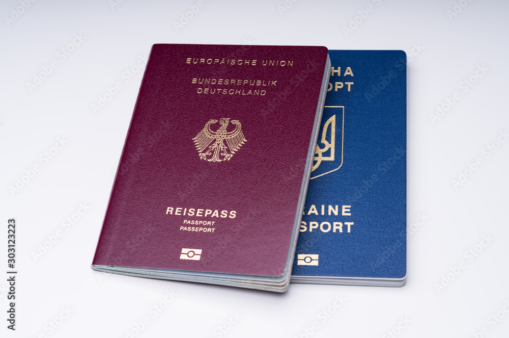 German And Ukrainian Passports Against White Surface German And Ukrainian Passports Against White Surface