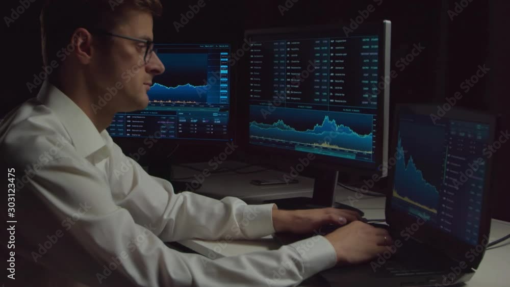 Trader working in office at night using workstation and analysis technology. Stock markets, crypto currency, global business, financial trading and banking. Trader working in office at night using workstation and analysis technology. Stock markets, crypto currency, global business, financial trading and banking.