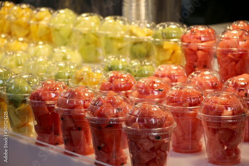 Chopped watermelons and melons in plastic glass at a street food market