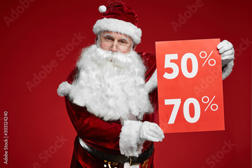 Wallpaper Mural Portrait of Santa Claus in beautiful red costume showing sign of big sale and looking at camera Torontodigital.ca