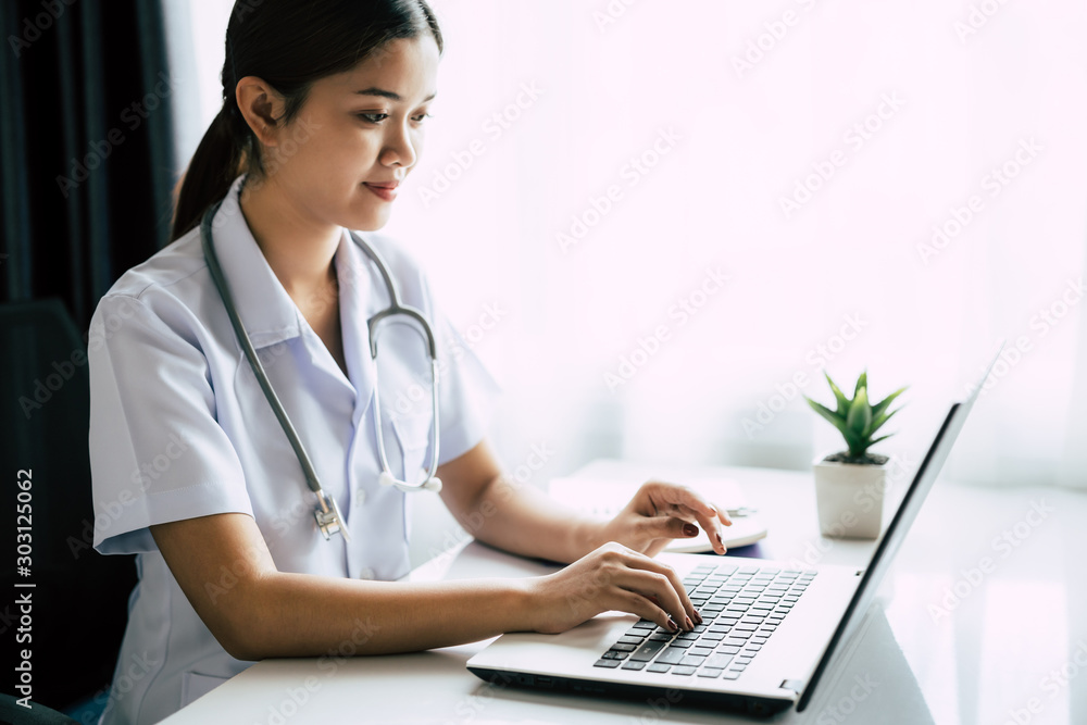 Young Asian woman doctor working with laptop in the hospital Young Asian woman doctor working with laptop in the hospital