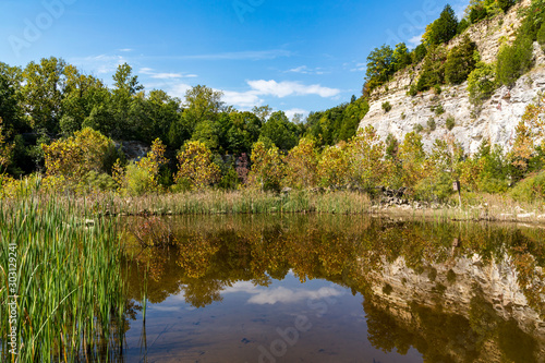 rural landscape with rock cliffs reflected in a lake