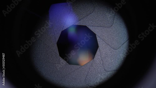 Rotating camera lens showing close up view of opening aperture iris blades