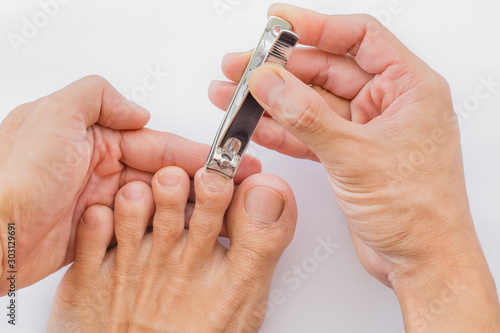 Man cuts his foot nails with tweezers on a white background. Nail care illustration For their good hygiene.