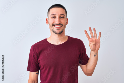 Young handsome man standing over isolated background showing and pointing up with fingers number four while smiling confident and happy.