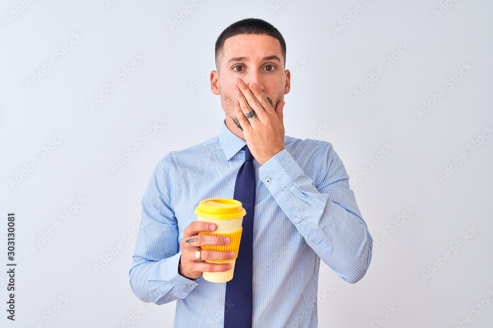 Young business man holding take away coffee over isolated background cover mouth with hand shocked with shame for mistake, expression of fear, scared in silence, secret concept Young business man holding take away coffee over isolated background cover mouth with hand shocked with shame for mistake, expression of fear, scared in silence, secret concept