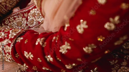 Pan close-up detailed reveal of bride's lehenga dress and decoration, slow motion, wedding in India. photo