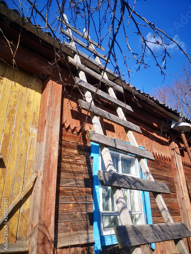 A wooden staircase leads to the roof of a village house