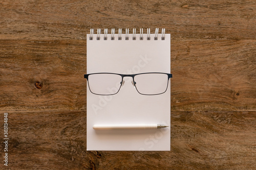 book, pen and glasses