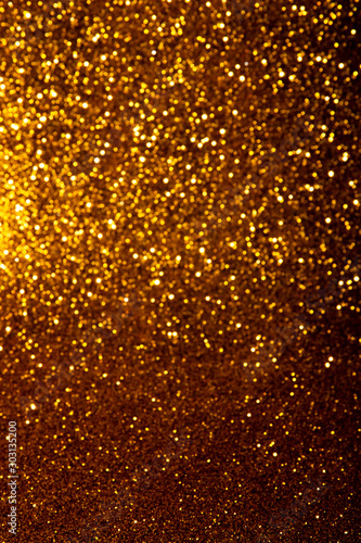 Abstract gold blured sparkling background with focused area. Holiday festive concept. Glitter confetti. Christmas lights.