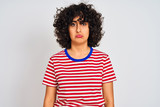 Young arab woman with curly hair wearing striped t-shirt over isolated white background depressed and worry for distress, crying angry and afraid. Sad expression.
