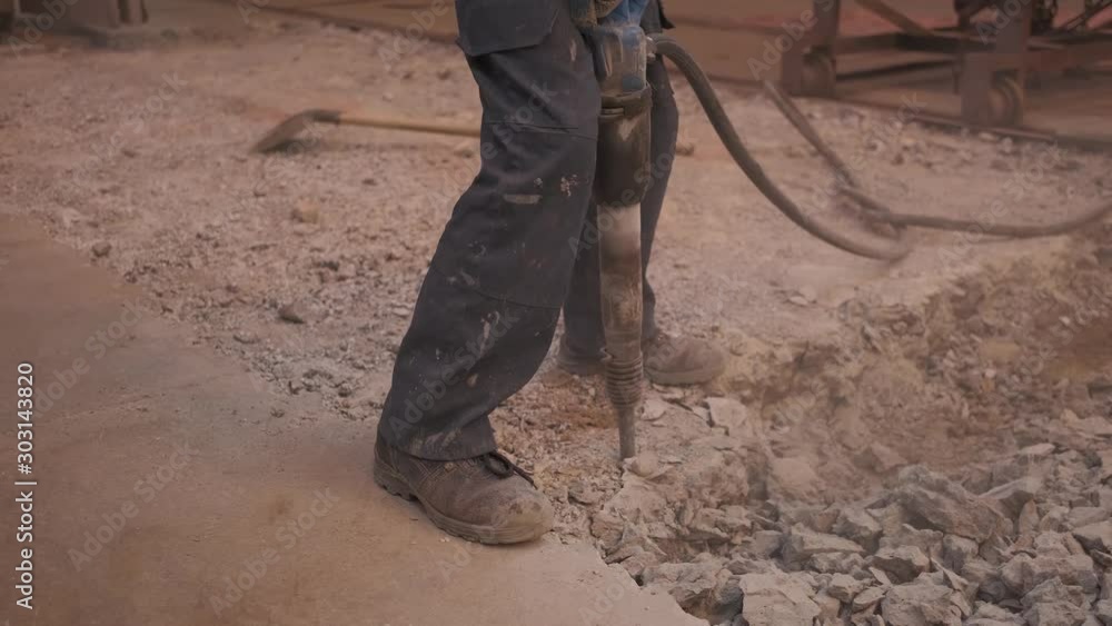 the Builder works with a jackhammer.asphalt surface repair the Builder works with a jackhammer.asphalt surface repair