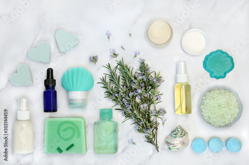 Rosemary herb skin care beauty treatment with cosmetic products on marble background. With anti ageing benefits & can reduce environmental skin damage. Flat lay, top view.
