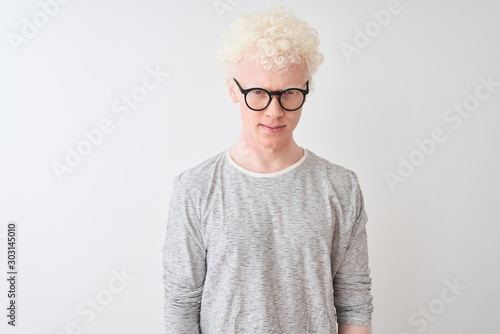 Young albino blond man wearing striped t-shirt and glasses over isolated white background skeptic and nervous, frowning upset because of problem. Negative person.