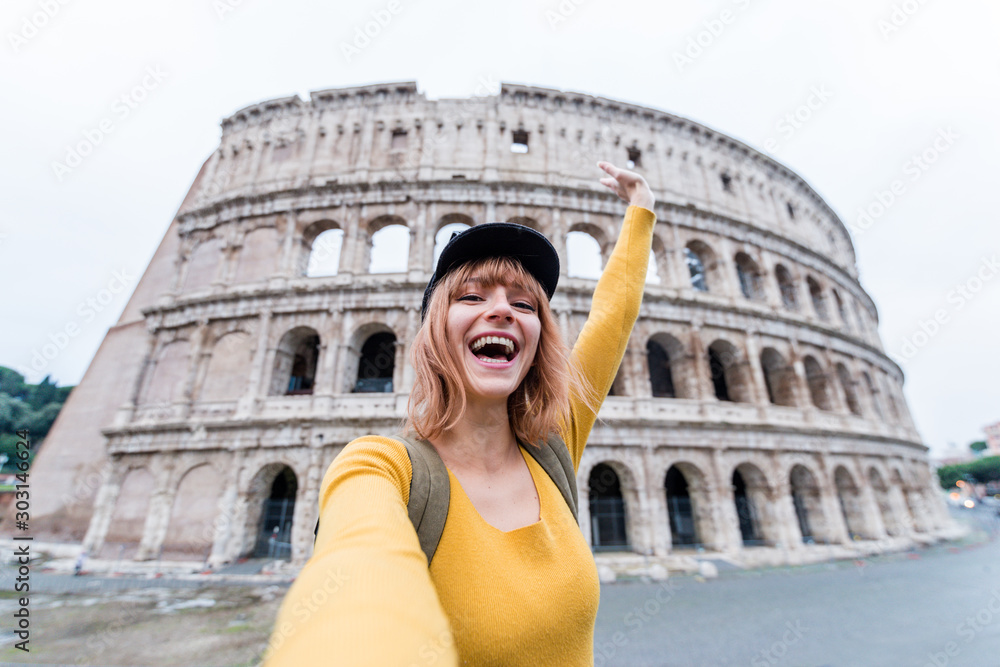 Happy beautiful young woman take a selfie at the Colosseum in Rome, Italy.