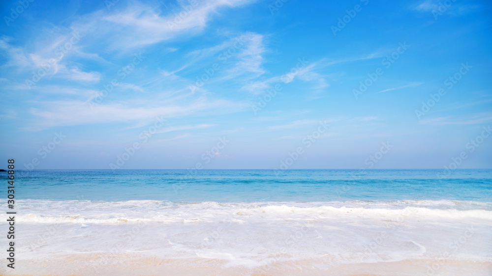 Fototapeta premium Tropical sandy beach with blue ocean and blue sky background image for nature background or summer design background