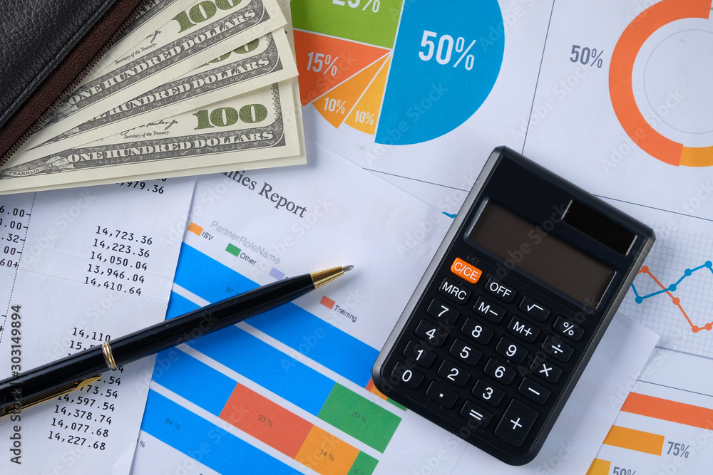 Financial reports on the table, business attributes, pen and calculator with banknotes in the wallet. Business growth concept background for business and money Financial reports on the table, business attributes, pen and calculator with banknotes in the wallet. Business growth concept background for business and money