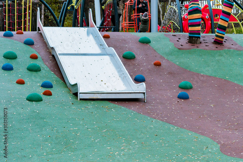 Children's playground double width stainless steel platform slide with safety wings in park. Outdoor. Leisure. Childhood
