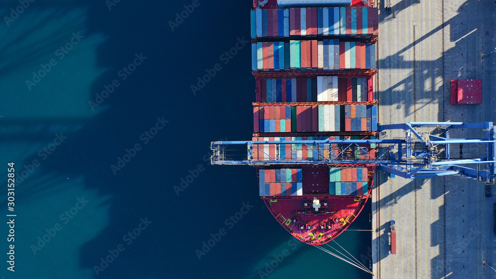 Aerial top down photo of industrial cargo container logistics terminal port with cranes loading unloading to container ships