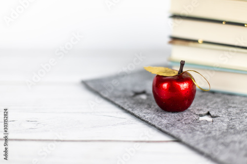 Czerwone jabłuszko i książki na stole