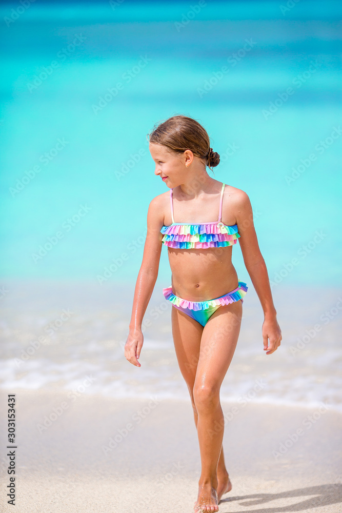 Adorable little girl on the beach during summer vacation