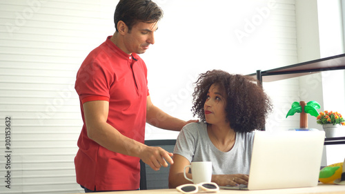 African and Hispanic couple supporting each other at freelance work from home photo