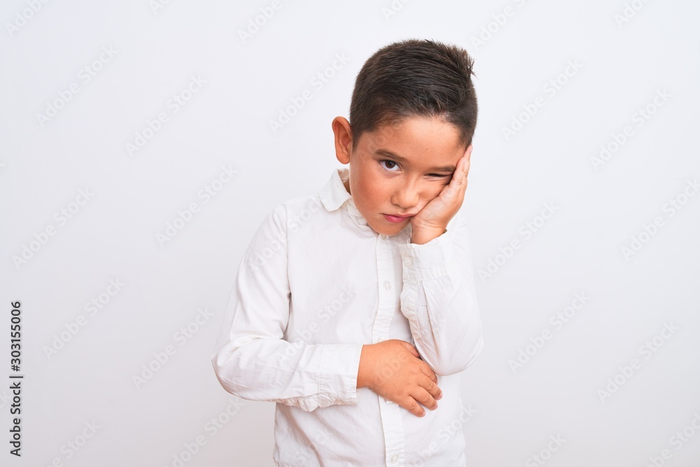 Beautiful kid boy wearing elegant shirt standing over isolated white background thinking looking tired and bored with depression problems with crossed arms. Beautiful kid boy wearing elegant shirt standing over isolated white background thinking looking tired and bored with depression problems with crossed arms.