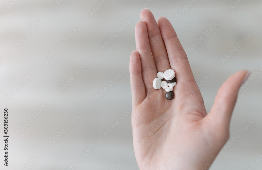 Probiotics, nutritional supplements and vitamins in the hand. The girl shows medical medicines. Harmless medicine capsules close up Probiotics, nutritional supplements and vitamins in the hand. The girl shows medical medicines. Harmless medicine capsules close up