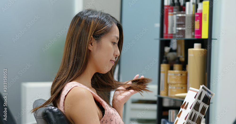 Woman look at color book of hair dye color at beauty salon Woman look at color book of hair dye color at beauty salon