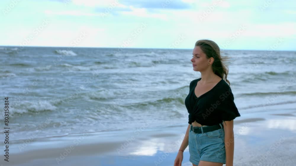 Attractive young girl walking beach during sunny day,slow motion Attractive young girl walking beach during sunny day,slow motion
