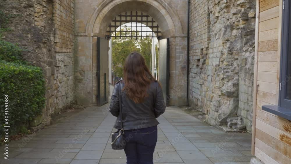 Woman walking near to the West gate of the Lincoln Castle, Wide angle, Lincolnshire, England. Woman walking near to the West gate of the Lincoln Castle, Wide angle, Lincolnshire, England.