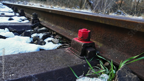 Rote Schraube am Bahngleis, Bahngleis im Winter, Schnee zwischen den Gleisen