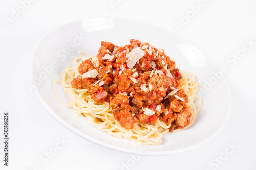 Spaghetti bolognese sprinkled with parmesan on a plate on a white background 