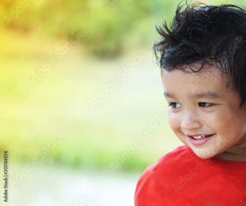 Portrait of cute happy Asian kid looking some one around.