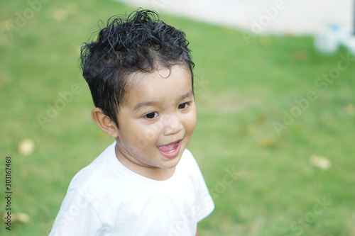 Portrait of cute happy Asian kid looking some one around.