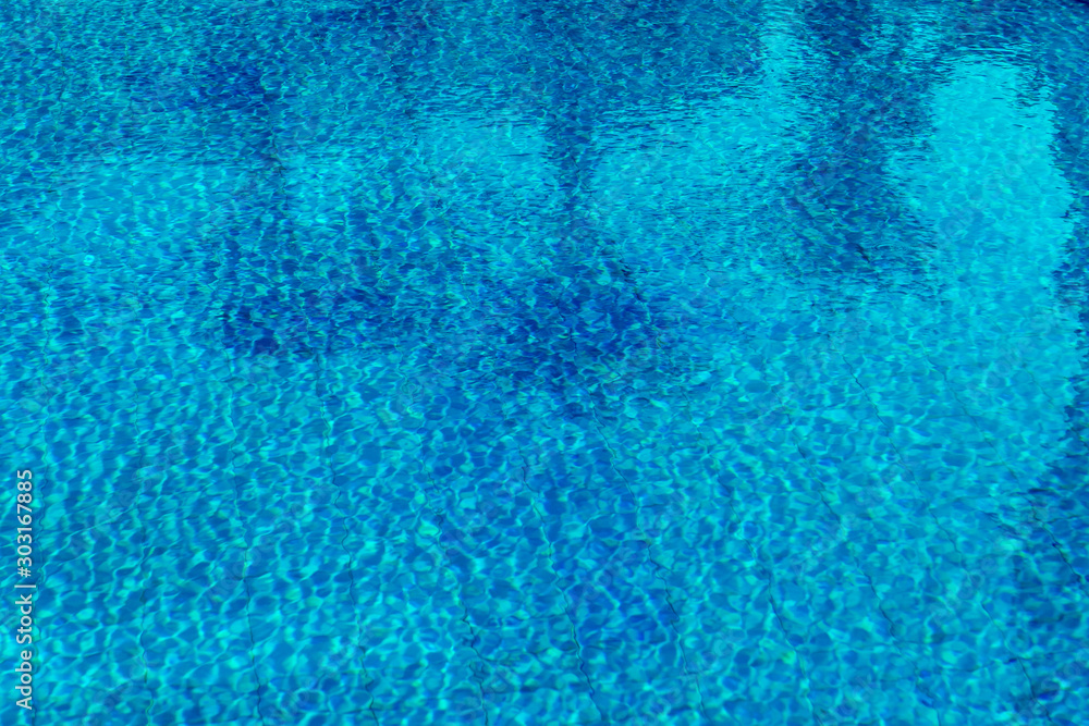 swimming pool water with palm trees and parasols reflected in it swimming pool water with palm trees and parasols reflected in it