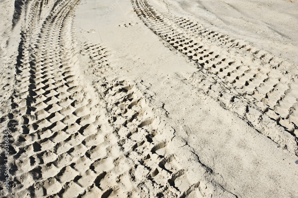 Fototapeta premium Earth mover tire tracks in sand quarry