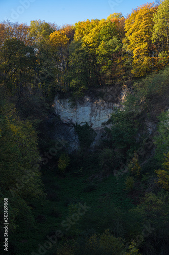 Small gorge at the Weilbergsee with autumn forest in the evening light.