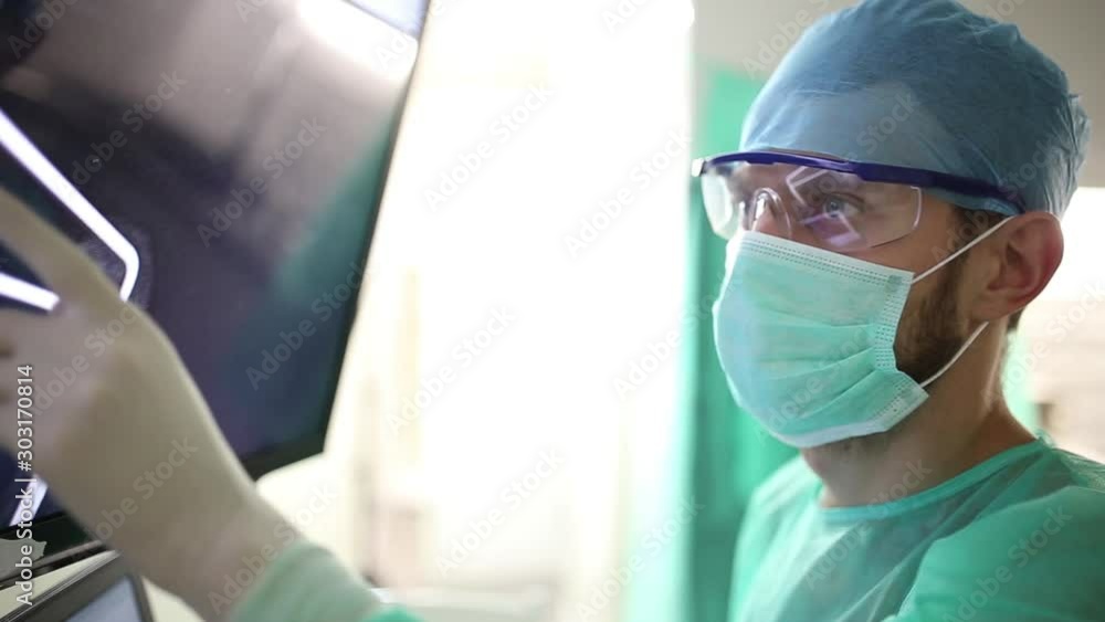 surgeon examines fluorography images on a monitor in an operating room of a medical office. surgeon examines fluorography images on a monitor in an operating room of a medical office.