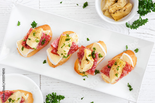 Canvastavla Crostini appetizers with brie cheese, salami and artichokes