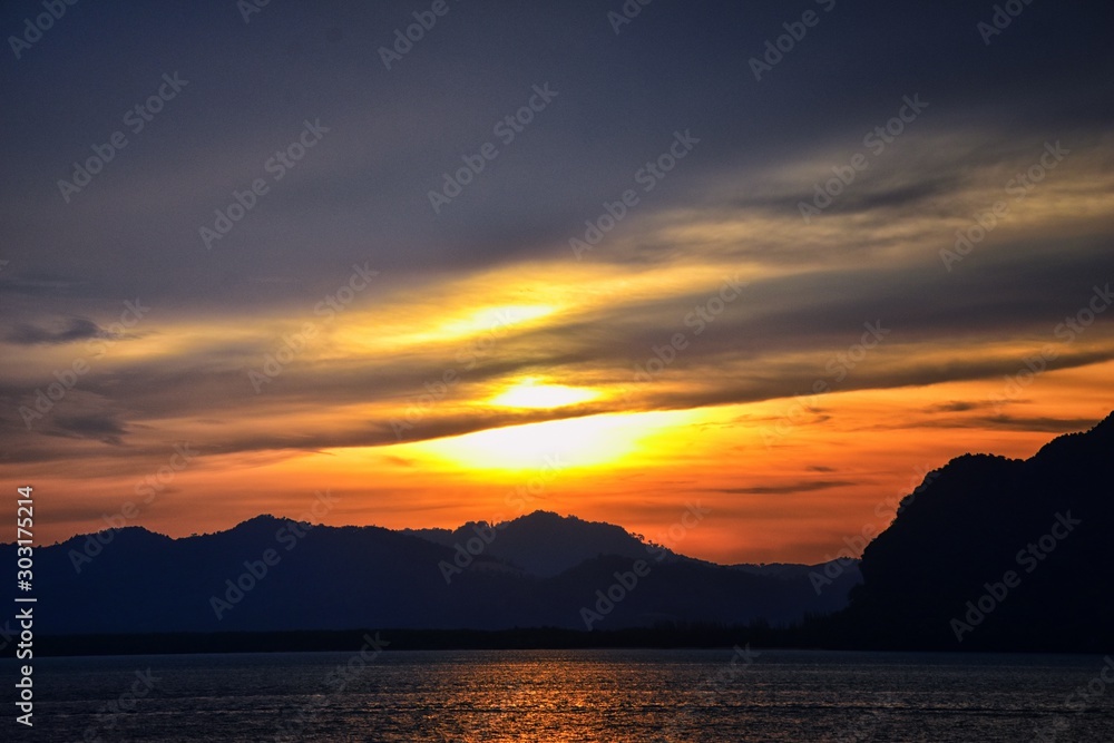 Islands Sunset, Ocean panorama views near Phuket with deep Red, Orange, Purple and Blue, mountains, twilight in Thailand. Including Phi Phi, Ko Rang Yai, Ko Li Pe and other islands. Asia.