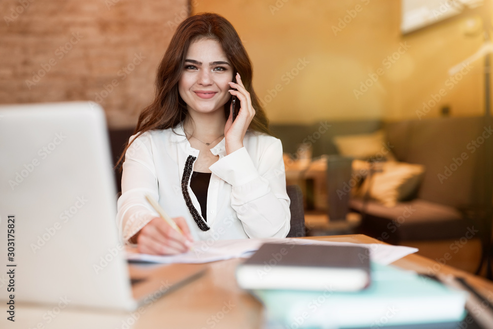 young beautiful woman working in her laptop speaking on the phone while having lunch in the cafe multitasking modern businesswoman young beautiful woman working in her laptop speaking on the phone while having lunch in the cafe multitasking modern businesswoman
